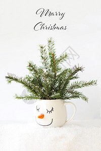 圣诞卡片雪树在一杯中与个沉睡的雪人脸乐趣微笑自然图片