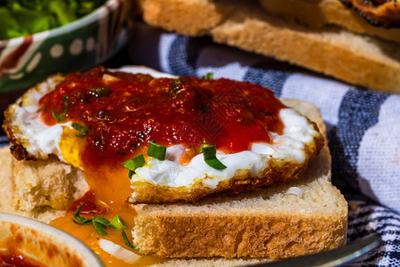 蛋黄用番茄酱和大蒜在烤面包上分离的煎蛋特写白色晴天图片