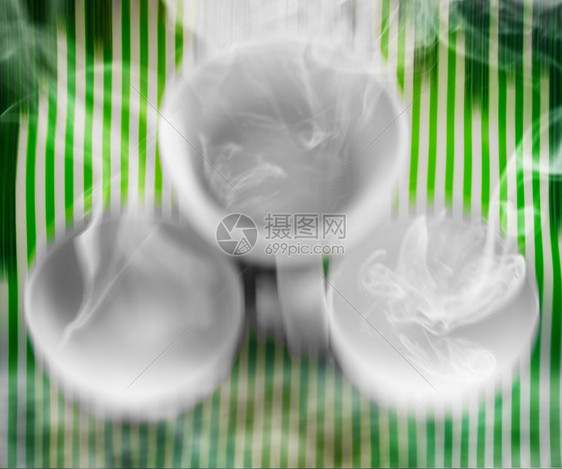 三个空的白色热杯在绿条纹上蒸汽干净的什锦热图片