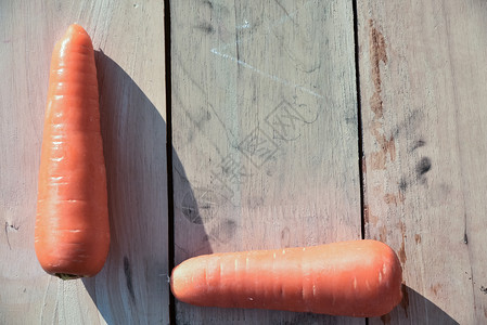 营养花园木地板上有叶的新鲜胡萝卜成熟图片