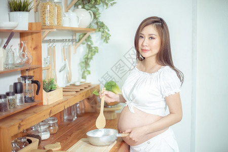 在室内健康食用蔬菜和水果的怀孕女妇厨房食物图片