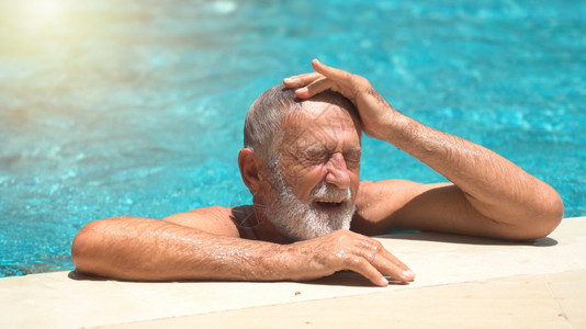 健康老年男子在户外游泳池蓝色的闲暇图片