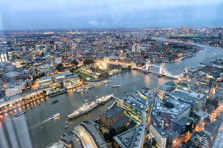 英语天线晚上在泰晤士河沿岸的塔桥和城市天际线空中观察伦敦联合王国塔桥和夜晚在泰晤士河沿线的城市天际街道图片