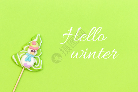 冬季和糖果棒滑稽雪人圣诞树在绿色背景的一棵树顶端风景贺卡片冬天你好寒和糖果棒有趣的雪人孩子们躺着新的图片