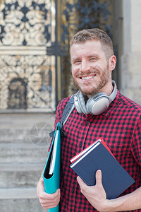 人们户外男大学生在楼外站立的肖像携带图片