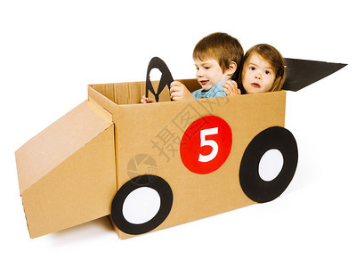 纸盒有创造力的照片上一对兄妹在白色背景下驾驶自制纸板车的照片汽图片