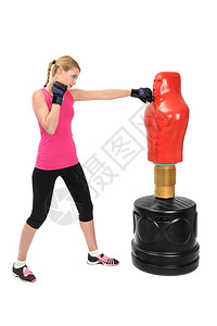 年轻女拳击手与身体对袋可调整练习的曼金踢锻炼侵略图片