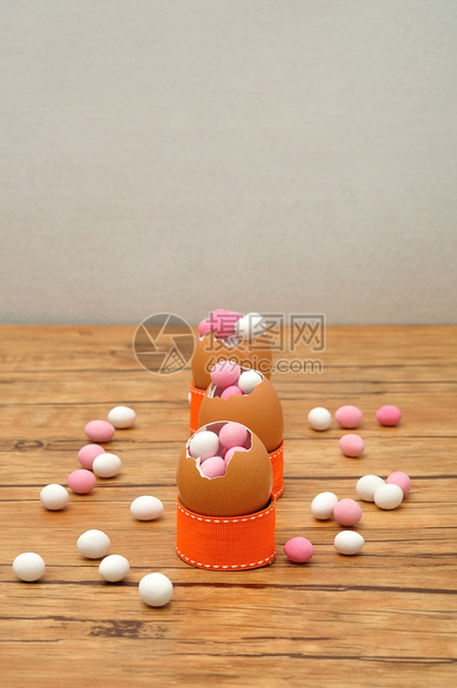 白色的饮食复活节填满了粉和白糖的空蛋贝壳展示在一张用于装饰东面桌的子上图片