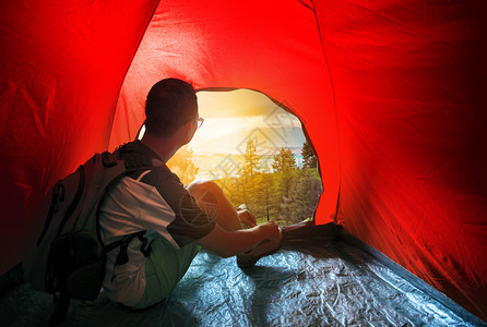 在户外帐篷露营的人寻找美丽太阳升起场景远足露营车背包图片