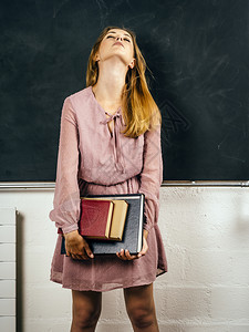 常设照片来自一位在课堂黑板前持有书籍的沮丧青年学生照片成人苦恼图片