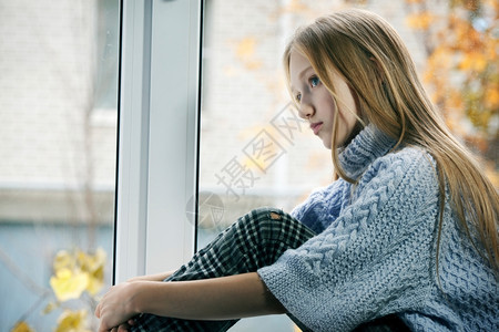 水毛衣人类一个长着金发头的悲伤女孩情感肖像她正坐在雨秋日的窗口上图片