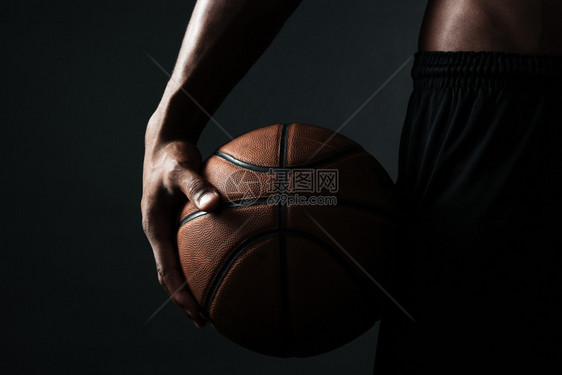 美国黑人裸肌肉男色背景的篮球运动员握着的剪裁照片图片