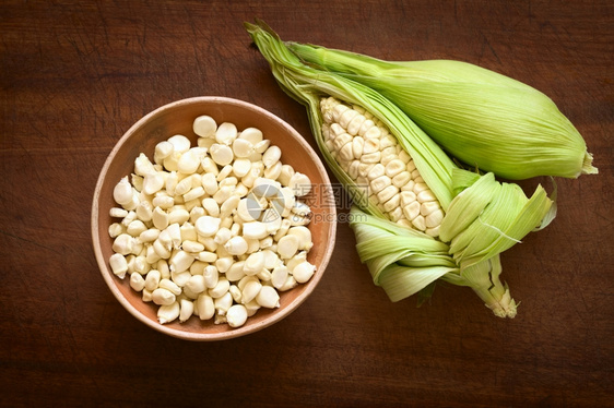 碗中的谷粒和称为Choclo西班牙语的白玉米棒子头顶照片用英语秘鲁或库斯科玉米通常在秘鲁和玻利维亚发现在自然光的木板上拍摄制的新图片