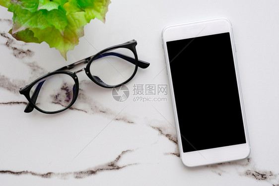 在职的白色大理石桌背景上空白屏幕和眼镜的智能电话用于模拟板技术和生活方式概念的模型技术和商业搜索图片