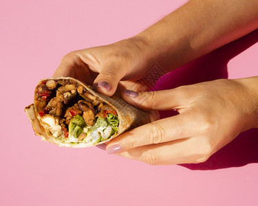 粉色背景上美味的墨西哥卷饼图片
