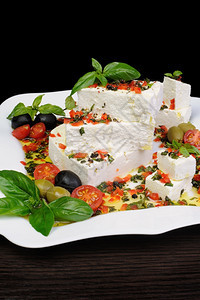 饮食油大块头罗勒和橄榄樱桃番茄的羊乳酪片图片