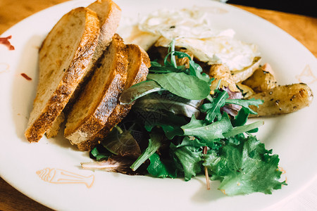 食物芝麻菜青健康早餐绿色和吐司在白盘子上的烤面包健康早餐绿色和吐司图片
