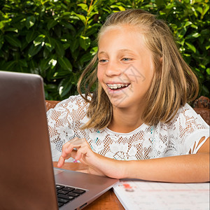 女孩蓝色的10岁美少女学生在电脑屏幕上有好消息Y我人们图片