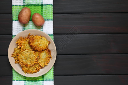 油条营养盘子上自制土豆煎饼或炸薯条德国传统菜盘用自然光照黑木头蔬菜图片