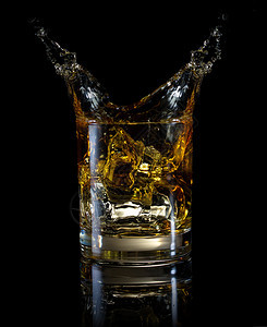 一杯威士忌和喷雾在黑色背景上被孤立一杯威士忌和喷雾降低波旁酒黄色的图片