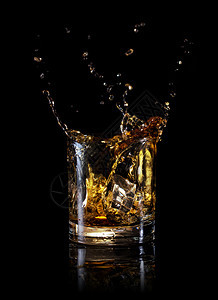 苏格兰人在黑底杯威士忌上被隔绝在黑色背景上的圆杯威士忌中喷洒降低圆形的图片