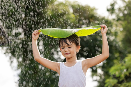 情绪享受头饰男孩微笑玩得开心站在她的头上叶子在雨中站立图片