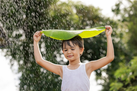 情绪享受头饰男孩微笑玩得开心站在她的头上叶子在雨中站立图片