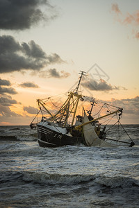 云拖网渔船颜色在荷兰海滩的滨渔船图片