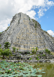 旅行天在泰国巴塔亚省高切昌悬崖上雕刻和涂有黄金的佛像激光蓝色图片