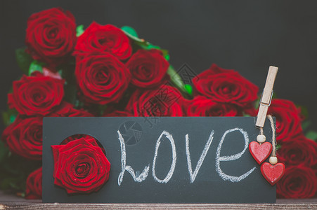 概念情人节爱这个词用粉笔写在盘子上一堆红玫瑰背景上时尚的爱情概念新鲜一种盛开图片