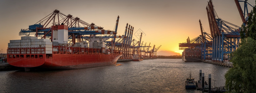 景观日落时在汉堡港的集装箱船舶水全景图片