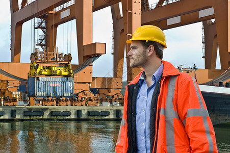一名工程师在港口环境中密切关注集装箱船的卸货携带进口水图片