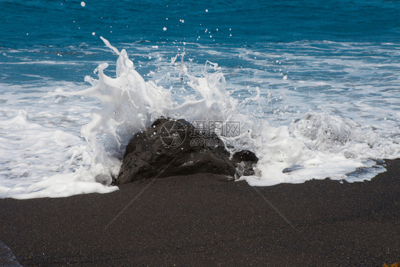溅起粗糙的海浪冲向滩上的石头黑沙加那利岛海浪冲向石头洋CanaryIsland天空图片