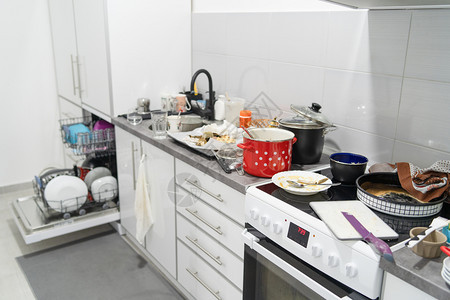 菜肴一种白色厨房的侧边视图在烹饪后一团乱糟的柜台用具和厨房电器上配有未洗过的脏锅和盘子碗图片