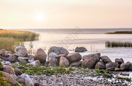 巨石日出黄昏夜晚湖边日落海岸的石头湖图片