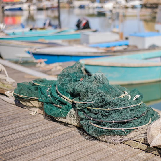 鱼海浪码头上的渔网底是船的网浮标图片