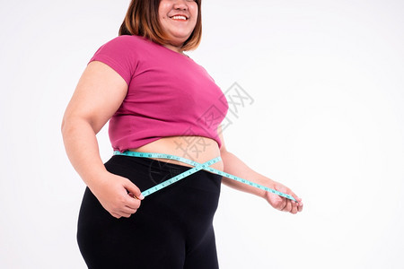 输一种损失体重超的妇女用白色背景测量她的腹部脂肪健康食物促进和生活方式的概念a健康食品促进和生活方式概念图片