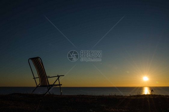 蓝色的孤单椅子在海平面的太阳落下水夏天图片