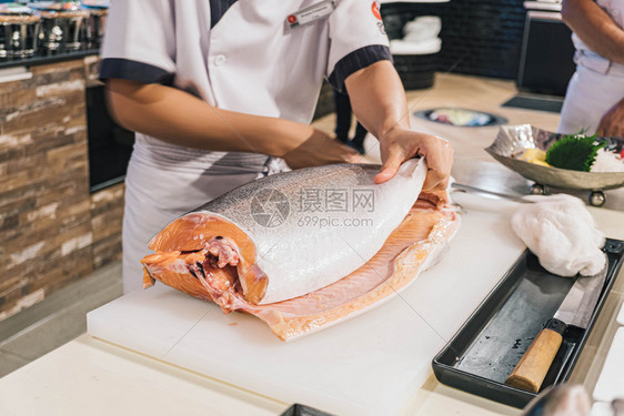 厨师在日本餐厅准备和切开新鲜鲑鱼饮食自然刀图片