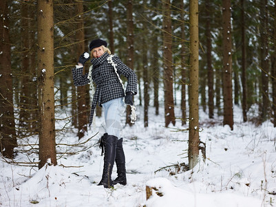 雪身着冬衣农村风景背森林的时装成熟年妇女天一月图片