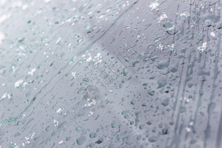 水蓝色的雪和玻璃上雨滴作为背景冷冻图片