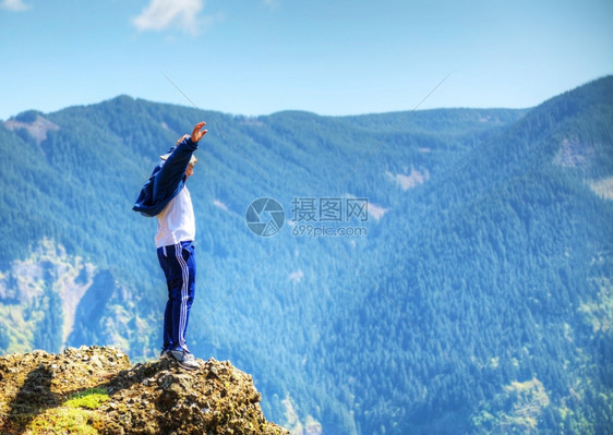 自然男人类生活在岩石边缘与山脉对齐的边动机图片