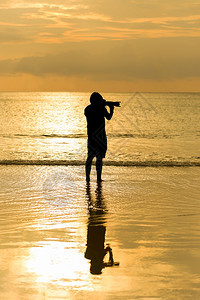 相机自然景观人摄影师拍时使用风景海日落背拍摄图片