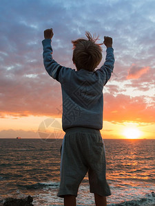 海边夕阳下的男孩图片