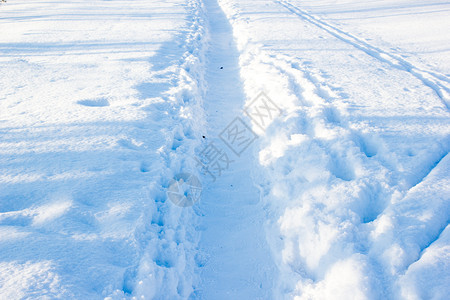 冬季足迹雪中的道路风景优美分支场图片