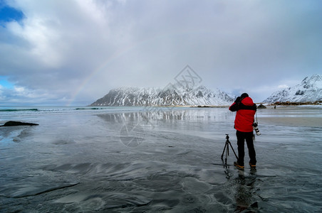 旅行海岸蓝色的山丘雪和摄影师与相机勇敢摄影师图片