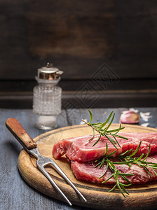 厨房血腥用木板和叉子加玫瑰的原生猪肉关上牛排图片