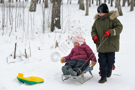 坐在雪橇上玩耍的孩子图片