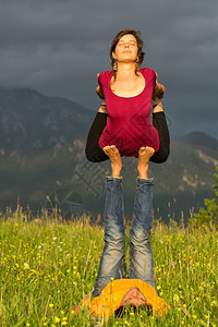 浓度团结健康山上具有男质的Acroyoga女孩图片