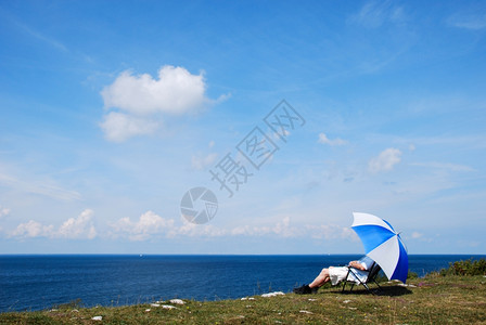 水草地平线坐在椅子上的人海边雨伞下放松在瑞典波罗的海风景美观之下图片